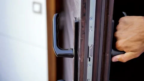 A man's hand opens and closes a brown wooden door  Stock Footage 169011738