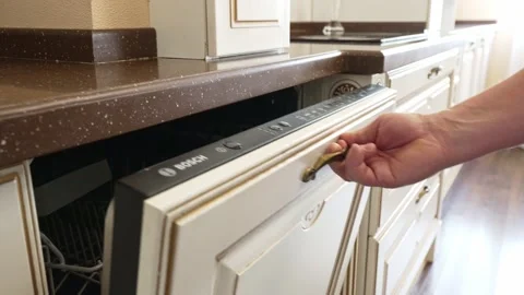 A man's hand opens and closes the built-in dishwasher door. Bosch Stock Footage 196821675