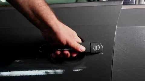A man’s hand opens the door handle of a dark grey car Vidéo 275145804