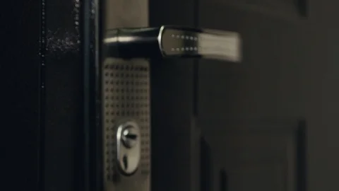 A man's hand opens the door with a key, a man in a black leather jacket enters Stock Footage 111754885