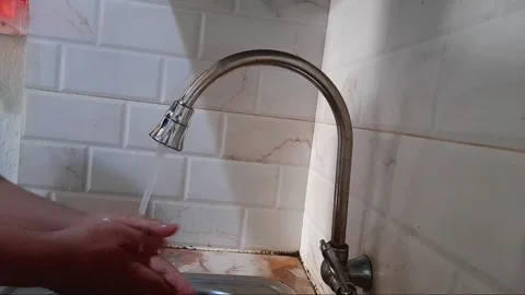 A man's hand opens the faucet in the kitchen to wash his hands without using soa Stock Footage 283977027