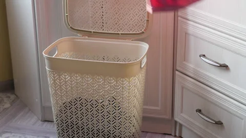 A man's hand opens a laundry basket and puts dirty clothes for washing on t.. Stock Footage 232497489