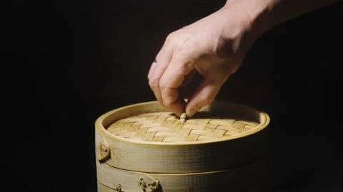 A man's hand opens lid of bamboo steamer box showing Chinese dumplings wonton Stock Footage 170547075
