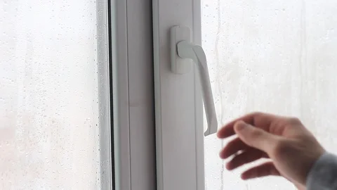 Man's hand opens plastic window facing the street Stock Footage 99880470