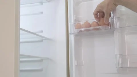 Man's hand opens refrigerator door and takes out raw egg, selective focus Stock-Footage 271068564