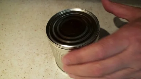 A man's hand opens a tin can of corn with a key. Stock Footage 75806895