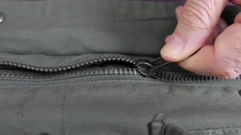 A man's hand opens a zipper Stock Footage 86815925
