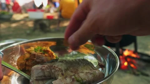 Man's hand parcels the boiled fish up to eat it. Tourist's lunch Stockbeeldmateriaal 138254307