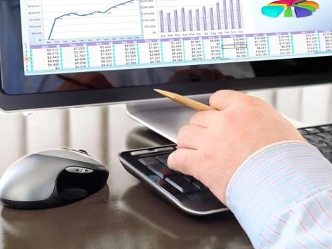 Man's Hand with Pen Typing at a Computer Keyboard Stock Photos