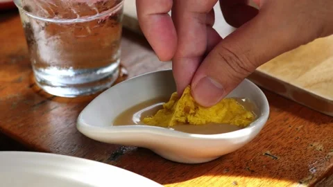 The man's hand picked up a dessert in a cup of condensed milk Stock Footage 157792911