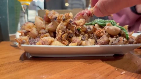 A Man’s Hand Picking Up Homemade Fried Calamari From a Plate. Spanish Tapas. Stock Footage 335181987