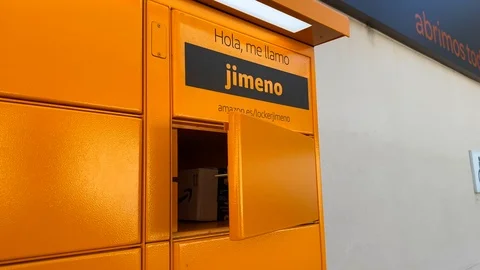 A man's hand picking up a package at the Amazon hub Locker pick up point Stock Footage 122948290