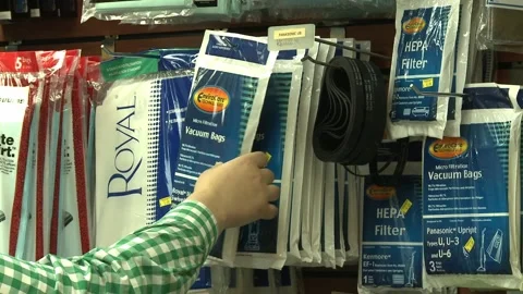 Man's Hand Picking Vacuum Bag Off Rack in Store Stock Footage 199734055