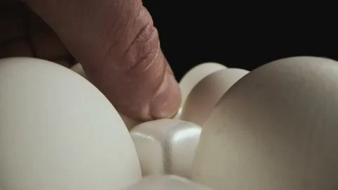 A man's hand picks up a raw chicken egg for cooking Stock Footage 153716043