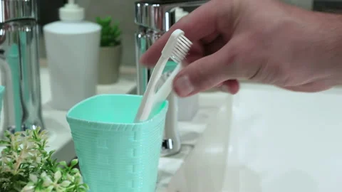 A man's hand picks up a toothbrush from a case in the bathroom, brush your teeth Stock Footage 212803553