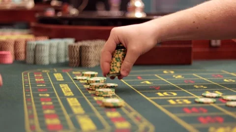 Mans hand placing casino chips on a roulette betting table. Close up. Stock Footage 321652971