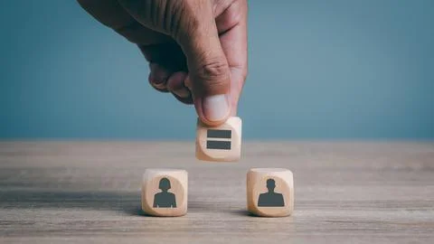 Man's hand is placing wooden blocks on the table, gender equality concepts,.. Stock Photos