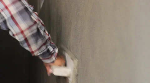 Man's hand plastering a wall with trowel. Construction worker at work. Construct Stock Footage 63910898