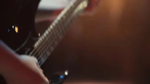 A mans hand playing the strings of an electric guitar, close-up Stock Footage 317806080