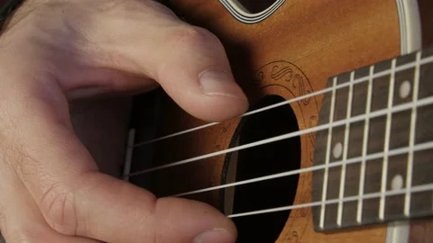 Man's hand plays ukulele. Close up deck view. Vídeos de archivo 155142730