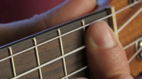 Man's hand plays ukulele. Close up neck fingerboard view. Stockbeeldmateriaal 155142932