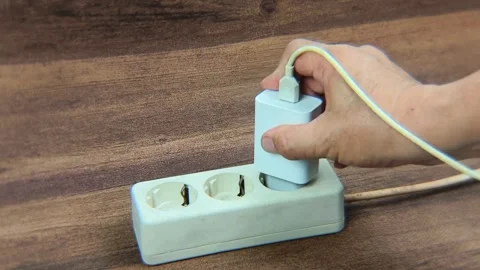 Man's hand plug a cell phone charger to the electrical socket. Stock Footage 338445696