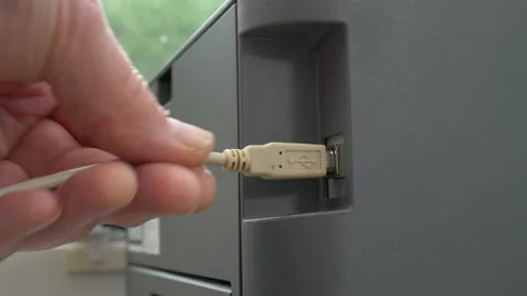Man's hand plugging a cable / cord  into the USB socket of a printer. Stock Footage 159142755