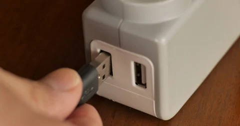 Man's hand plugging in a USB type A plug into a charging port adapter Stock Footage 92741871