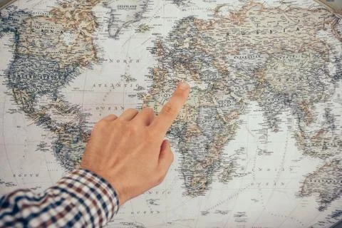 A man's hand is pointing at the map, close-up Stock Photos