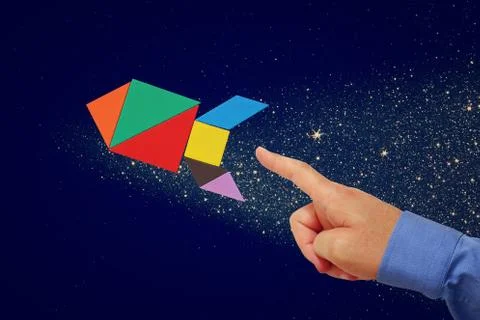 Man's hand pointing at rocket made from tangram puzzle Stock Photos