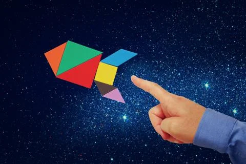 Man's hand pointing at rocket made from tangram puzzle Stock Photos