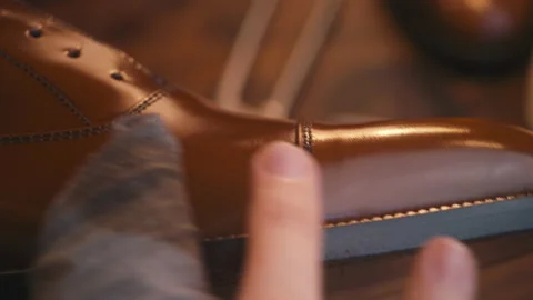 A man's hand polishes a leather boot. close-up, very beautiful Stock Footage 140410554