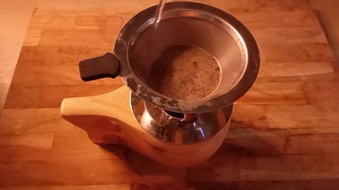 Man's hand pouring warm water into the coffee dripper Stock Footage 340357598
