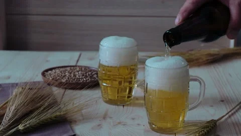 Man's hand pours beer into glasses Stock Footage 201211729