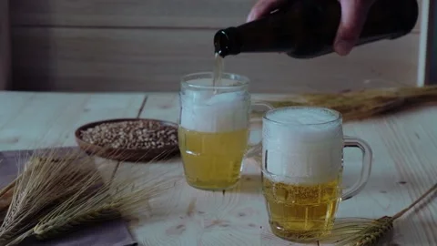 Man's hand pours beer into glasses Stock Footage 201211730