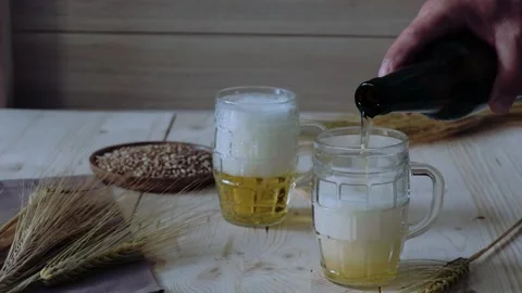 Man's hand pours beer into glasses Stock Footage 201211731