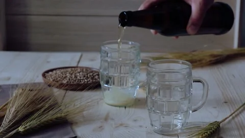 Man's hand pours beer into glasses Stock Footage 201211735