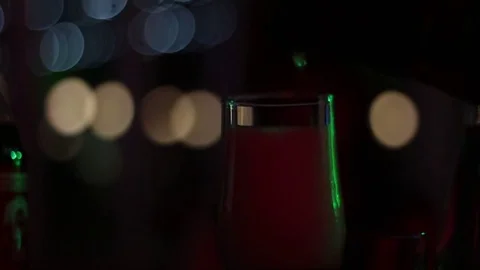 A man's hand pours a sparkling wine into a glass in the dark room of a nightclub Stock Footage 78204372
