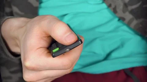 Man's hand presses OFF button on the remote Foto stock