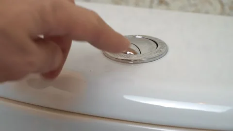 A man's hand presses the double flush button on the toilet. Video stock 147749502