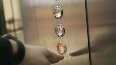 Mans hand presses elevator button to move down. view inside glass elevator Stock Footage 233779534