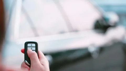 Man's hand presses on the remote control car alarm systems. Stock Photos