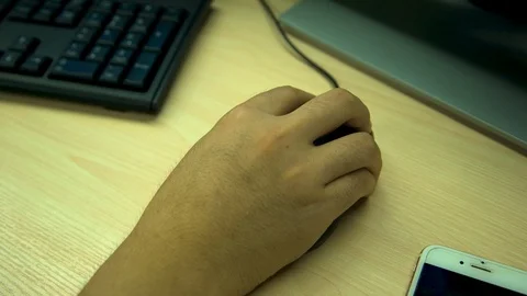 A man's hand pressing a button on a mouse attached to a computer Stock Footage 96225627