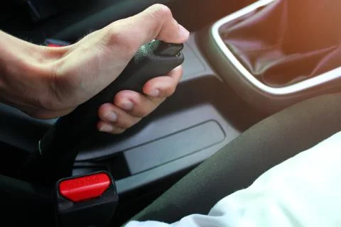 The man's hand is pressing the button to release the handbrake Stock Photos