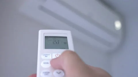 A man's hand pressing the buttons on the control of a split air conditioner Video stock 203211477