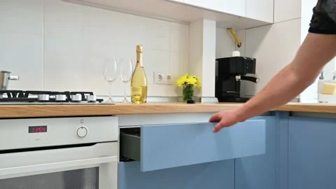 Man's hand pulling and closing a drawer at modern blue-teal and white kitchen Stock Footage 152311940