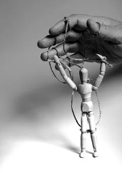 Man's hand pulling strings of wooden puppet. Concept of emotional manipulatio Stock Photos