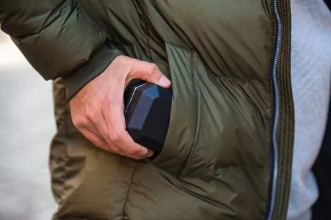 Mans hand pulls out a black jewelry box with wedding ring from a pocket. Man in Stock Photos