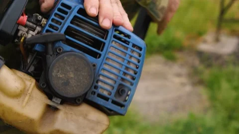 A man's hand pulls the starter rope gasoline trimmer and engine starts Video stock 190877969