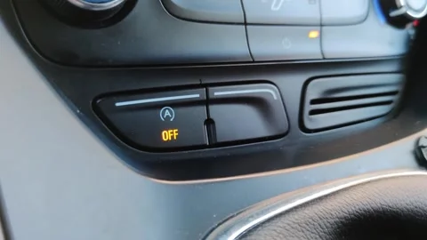 A man's hand pushes the engine start stop button in the interior of a modern car Stock Footage 256444813